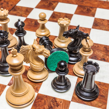 Overhead close-up of Apollo ebony and boxwood chess pieces on the 60 cm Toscana chess board