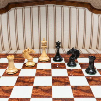 Wide view of Apollo lacquered ebony and boxwood chess pieces during play on the 60 cm Da Vinci chess board