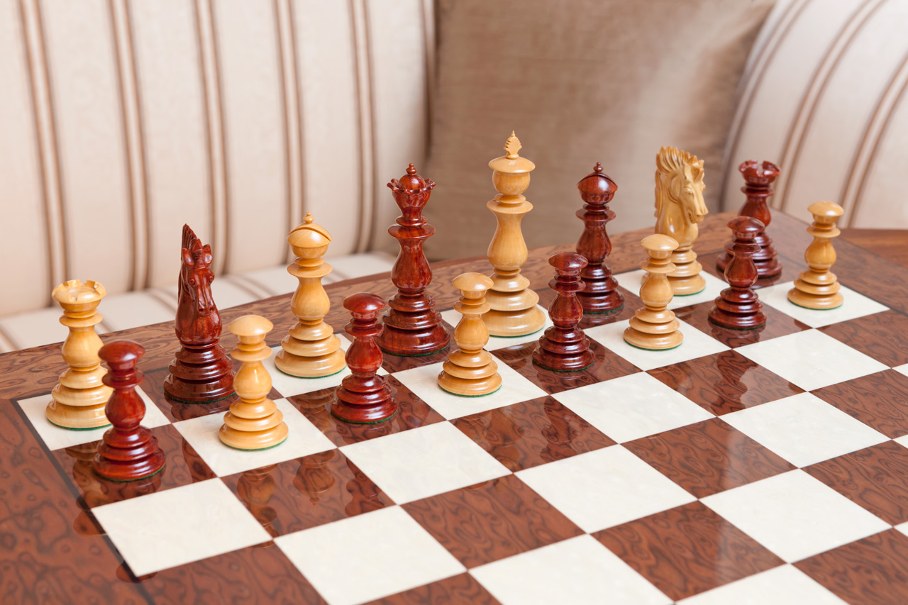 Dali padauk and boxwood pieces arranged for play on the Segovia board