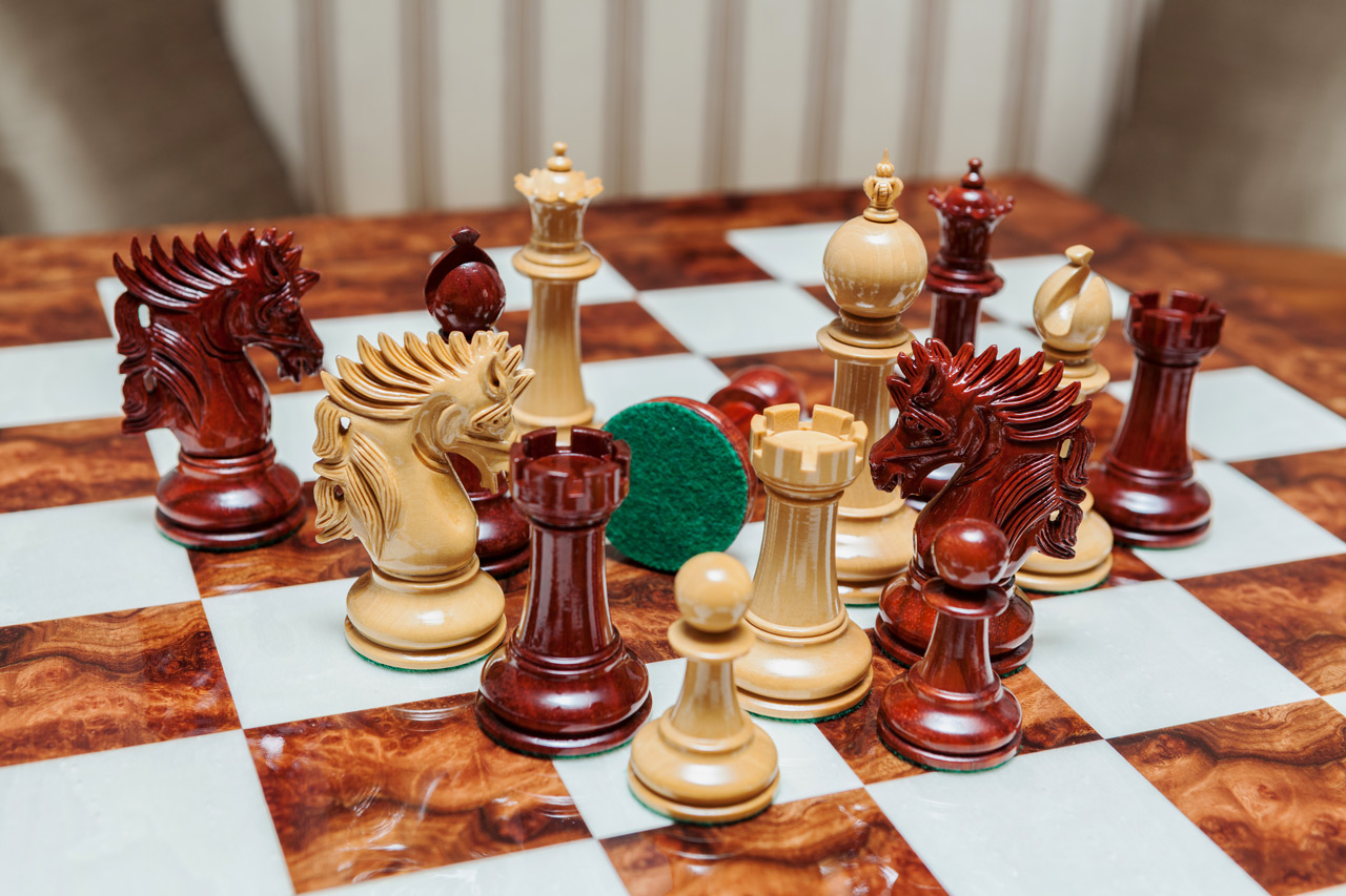 Shown with: 60 cm Da Vinci chess board Overhead close-up of Duke lacquered padauk and boxwood chess pieces with a green felt base on the 60 cm Da Vinci chess board