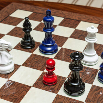 Overhead view of Earl red, white, navy blue and black chess pieces on the 50 cm Cordoba chess board