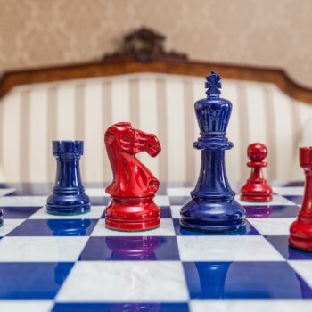 Earl red and navy blue chess pieces viewed at board level on the 51 cm Capri chess board