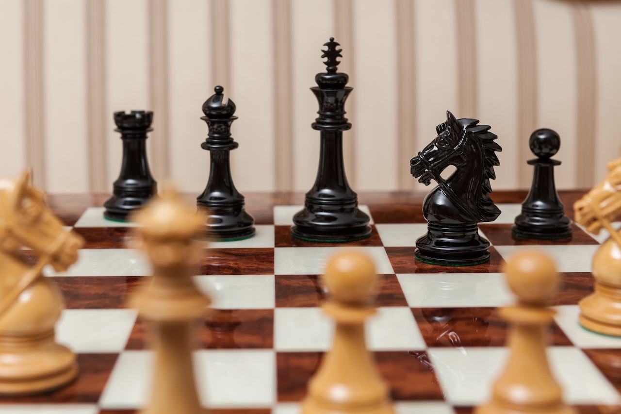 Regal lacquered ebony and boxwood chess pieces viewed from the ebony side on the 60 cm Da Vinci chess board
