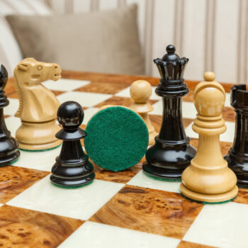 Shown with: 51 cm Venezia chess board Close-up of Viking lacquered boxwood and ebony chess pieces with a green felt base on the 51 cm Venezia chess board