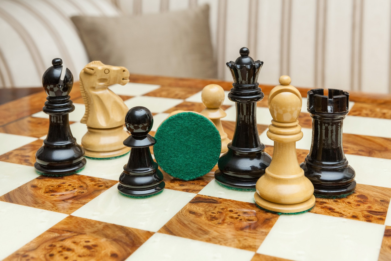 Shown with: 51 cm Venezia chess board Close-up of Viking lacquered boxwood and ebony chess pieces with a green felt base on the 51 cm Venezia chess board
